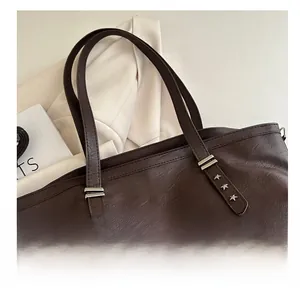 Detail of silver star rivets on premium brown faux leather tote bag shoulder strap