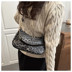 Dettaglio della borsa hobo leopardata alla moda con tracolla a catena dorata