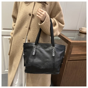 Detail of black faux leather tote with silver star rivets on the shoulder strap