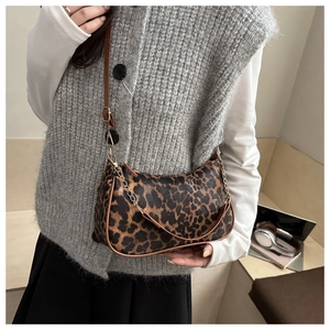 Dettaglio borsa leopardata con tracolla in pelle e catena decorativa in metallo dorato