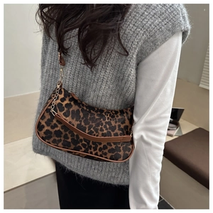 Dettaglio della borsa hobo leopardata con tracolla in pelle marrone e catena d'oro