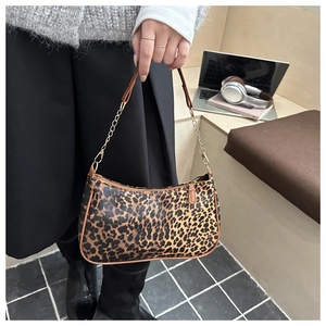 Dettaglio borsa a mezzaluna leopardata vintage con catena in metallo e finiture PU