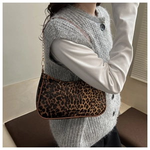 Dettaglio borsa a spalla leopardata con catena indossata da modella per prospettiva