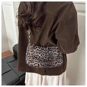 Dettaglio borsa leopardata con tracolla marrone regolabile e catena dorata elegante