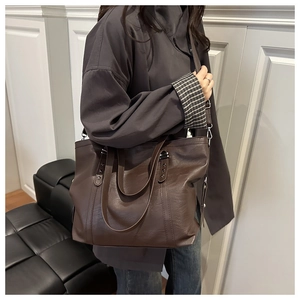 Close-up of the vintage brown leather tote bag showing fine texture and star rivet detail