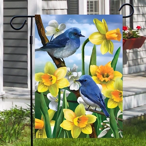 Gartenfahne mit blauen Vögeln und gelben Blumen an einem schwarzen Metallhalter im Garten