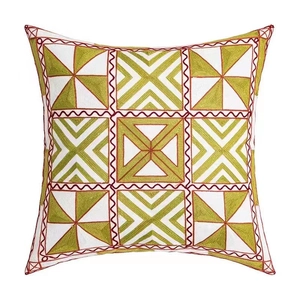Housse de coussin carrée avec broderie verte et coutures ondulées rouges sur tissu blanc