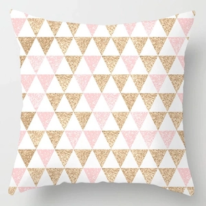 Dettaglio della fodera per cuscino in peluche con motivi geometrici a triangolo rosa e oro