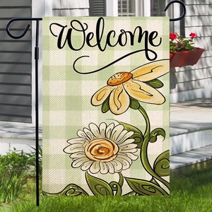 Welcome spring garden flag with daisy print and black metal stand in outdoor setting