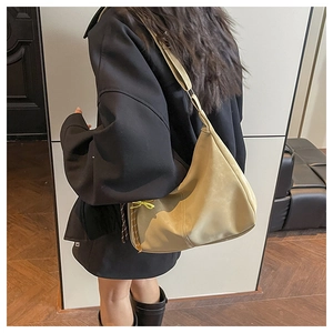 Close-up of beige minimalist large capacity shoulder bag with yellow decorative drawstring detail