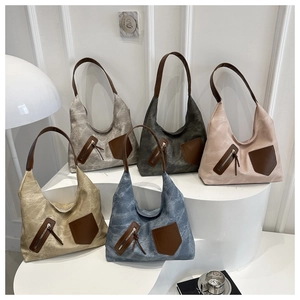 Detail of vintage washed canvas hobo bags with leather trim and metal zippers