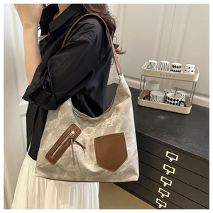 Close-up of canvas tote bag with marble pattern and brown leather straps for commuting