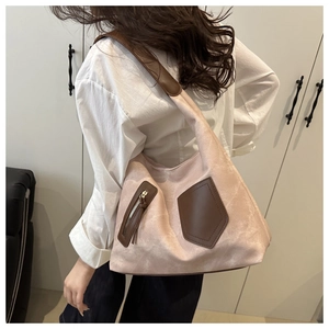 Detail of pink matte tote bag featuring brown leather shoulder straps and zip pockets