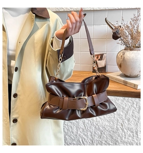 Dettaglio borsa tote plissettata marrone scuro con fibbia dorata e tracolla a catena
