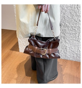 Dettaglio borsa shopper marrone scuro con fibbia a cintura e catena metallica dorata