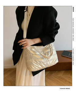 Detail of white quilted puffer crossbody bag with adjustable strap worn by model