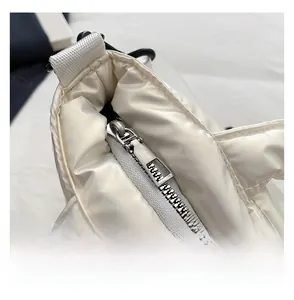 Detail of smooth metal zipper and white quilted padded fabric on a winter tote bag