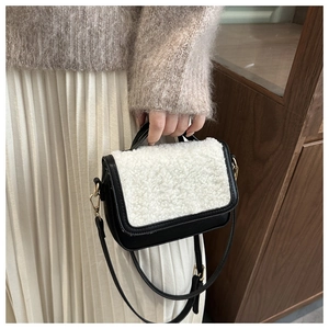 Detail of vintage saddle bag featuring black leather and white faux shearling texture