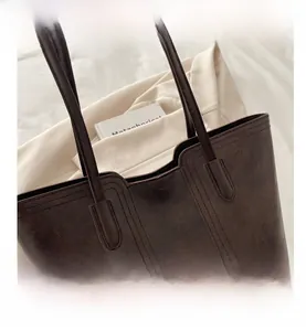 Detail view of deep brown tote bag with vintage texture and sleek shoulder strap