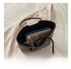 Internal view of dark brown leather tote bag showing large capacity for tablet and daily items