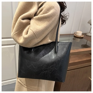 Detail of black tote bag featuring retro wrinkled texture and vertical decorative stitching