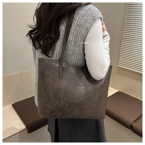 Detailed back view of a large vintage tote bag with textured synthetic leather and long straps