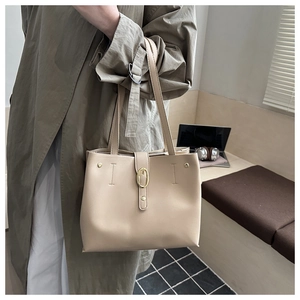 Détail du sac cabas beige avec boucle dorée ovale et surpiqûres décoratives