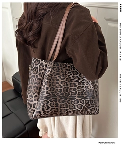 Close-up of leopard print tote bag texture with brown straps on model shoulder