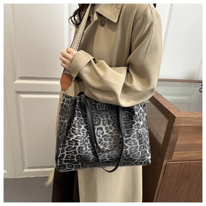 Macro shot of large leopard print tote bag featuring a detachable wide geometric strap