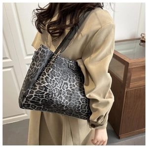 Model wearing a large leopard print tote bag showing capacity and style for autumn