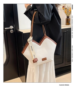 Dettaglio della borsa intrecciata bianca con finiture in pelle marrone e scollo a V