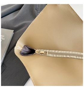 Dettaglio della borsa tote in pelle crema con cerniera dorata e cuciture raffinate