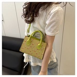 Detail showing cute cherry print on the green crossbody small square bag for women