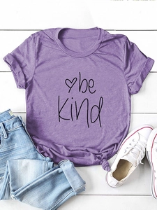 Flat lay of purple 'be kind' t-shirt with knotted hem, blue jeans and white shoes