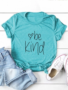Flat lay of teal be Kind t-shirt with knotted hem, blue jeans and canvas sneakers