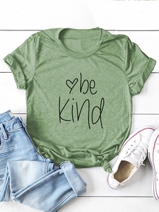 Detail view of grass green cotton T-shirt with black Be Kind print and side knot detail