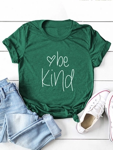 Detail of green Be Kind t-shirt with heart graphic and stylish front knot design