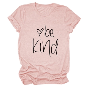 Detail of soft pink cotton t-shirt featuring be kind text print and small heart graphic