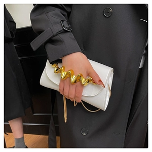 Close-up of white clutch with gold wavy clasp on a black coat backdrop