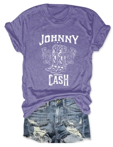 Flat lay of purple Johnny Cash t-shirt with floral cowboy boots and ripped denim shorts
