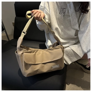 Dettaglio della borsa a tracolla in nylon kaki con patta e patch in pelle logo FASHION