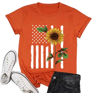 Flat lay of an orange sunflower American flag T-shirt with white shoes and black jeans
