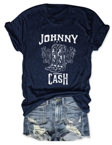 Flat lay of Johnny Cash graphic navy tee with floral boots and distressed denim shorts