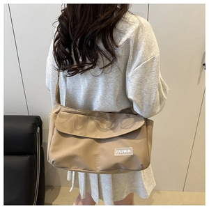 Dettaglio della borsa a tracolla in nylon kaki impermeabile con etichetta fashion su modello