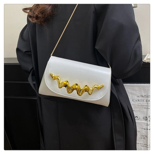 Detail of white glossy crossbody bag featuring wave-shaped gold metal buckle and chain strap