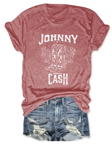 Flat lay of Johnny Cash graphic t-shirt with floral boots and distressed denim shorts
