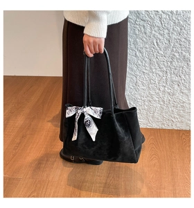 Détail d'un cabas en velours noir avec un élégant foulard en soie sur l'anse