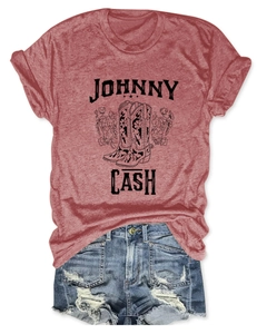 Flat lay of Johnny Cash graphic t-shirt with floral boots and distressed denim shorts