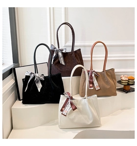 Sacs cabas en daim en quatre coloris avec foulards décoratifs sur présentoir blanc
