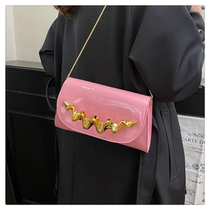 Detail of pink patent leather crossbody bag with golden wave metal trim on shoulder